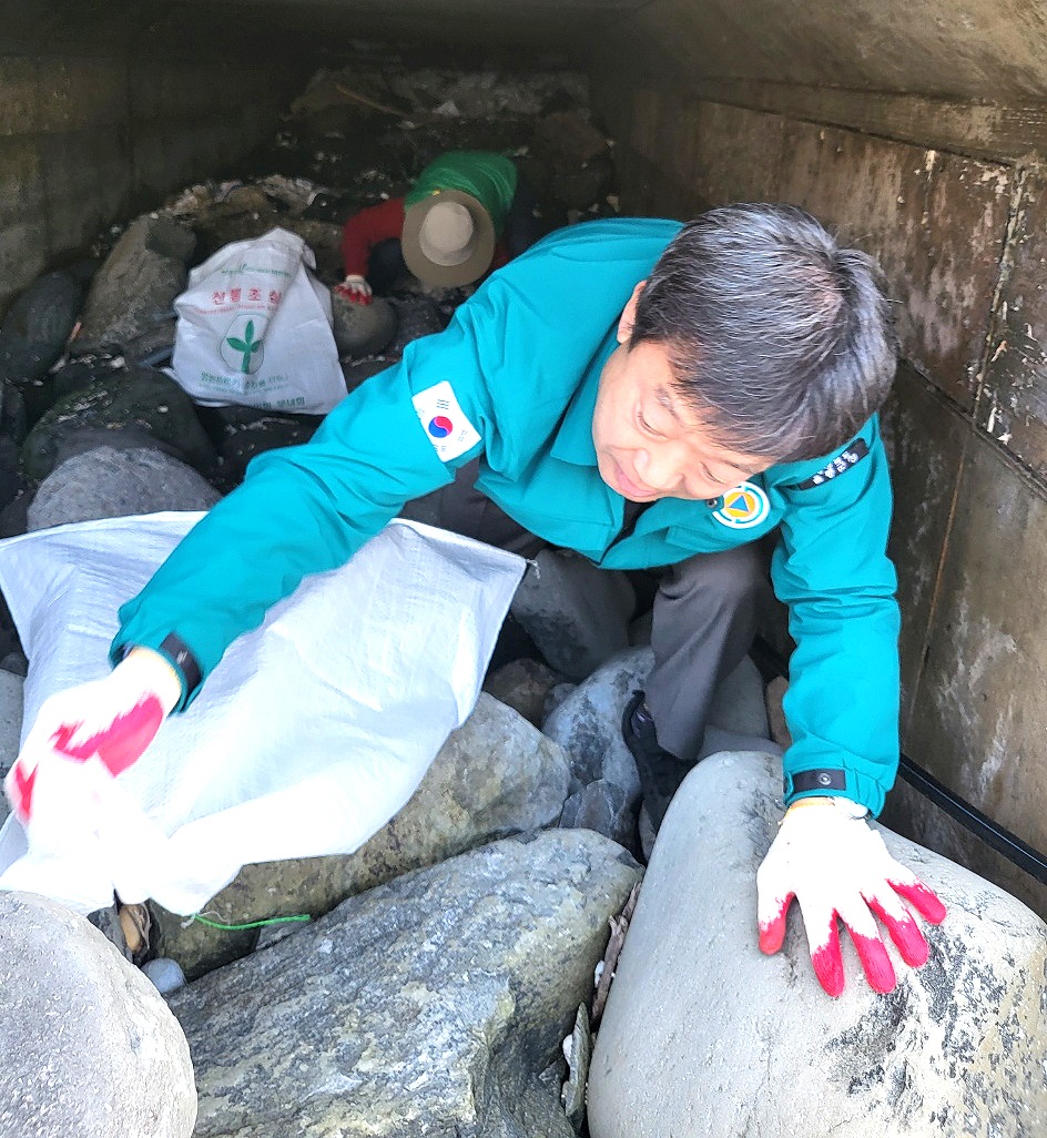 국토대청결운동 현장에서 남한권 울릉군수가  접근하기가 힘든 좁은 통로애서 쓰레기를 수거하고 있다(울릉군 제공)