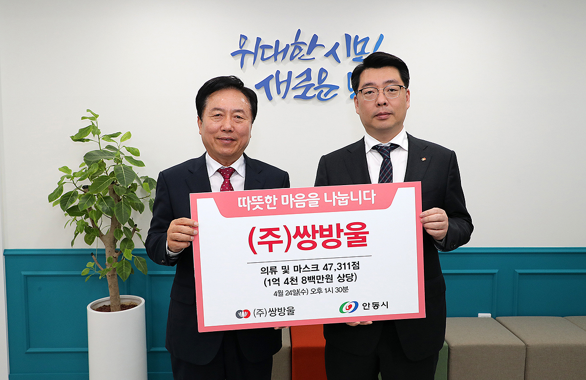 쌍방울 이형석 대표(오른쪽)가 안동시에 내의와 마스크 등 1억4800만원 상당 물품을 전달한 뒤 권기창 시장과 기념촬영을 하고 있다.(안동시 제공)