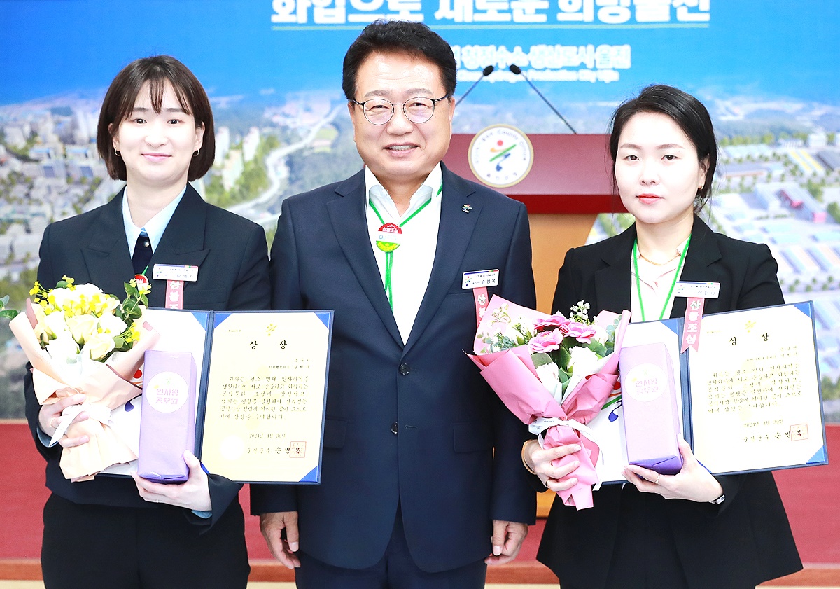 울진군 4월 인사왕을 뽑힌 근남면 이현아(오른쪽)주무관과 총무과 황혜지 주무관이 손병복 군수와 기념사진을 찍고 있다(울진군 제공)