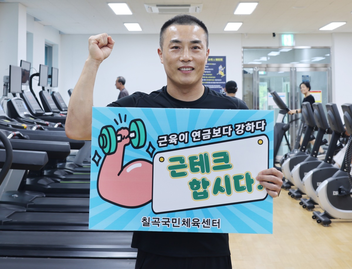 김용옥 칠곡국민체육센터장이 근테크의 중요성을 알리는 푯말을 들고 기념 촬영을 하며 회원 유치에 나섰다.[칠곡군 제공]