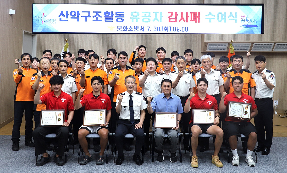 유공감사패를 전달 받은 강변레프팅 직원들과 김장수 서장등 소방관계자들이 파이팅을 외치며 기념사진을 찍고 있다(봉화소방서 제공)