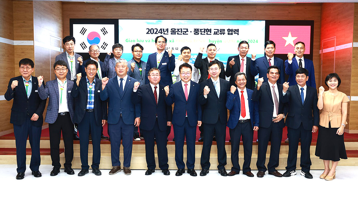 손병복 군수(앞줄 가운데)가 베트남 풍딘현 방문단과 단체 기념사진을 찍으며 파이팅을 외치고 있다(울진군 제공)