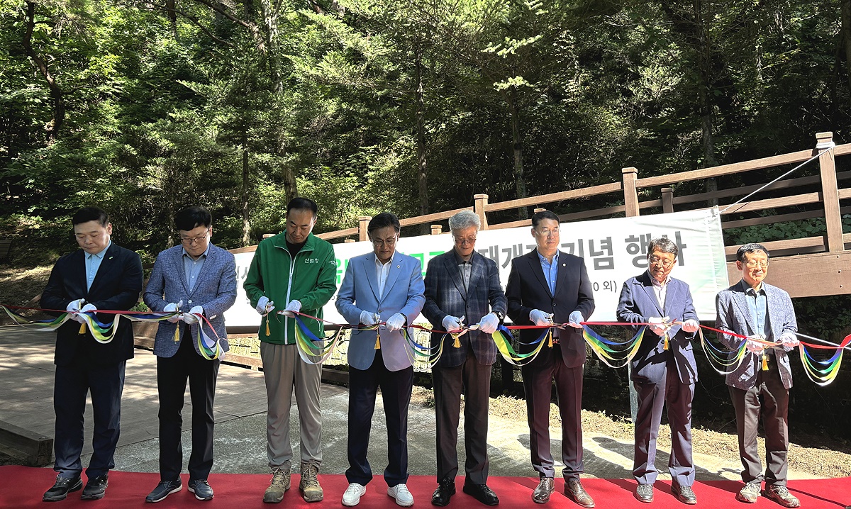 지난해 집중호우와 산사태로  피해를 입은 국립산림치유원의 데크로드 피해복구공사가 마무리돼 재개장 기념행사에 참석한 관계자들이 테이프를 커팅하고 있다(국립산림치유원 제공)
