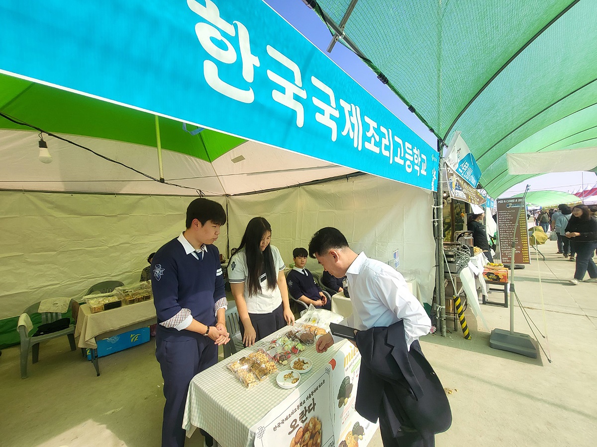 축제장을 찾은 한 관광객이 한국국제조리고등학교 학생들이 만든 제빵류를 맛보고 있다(사진=김성권 기자)