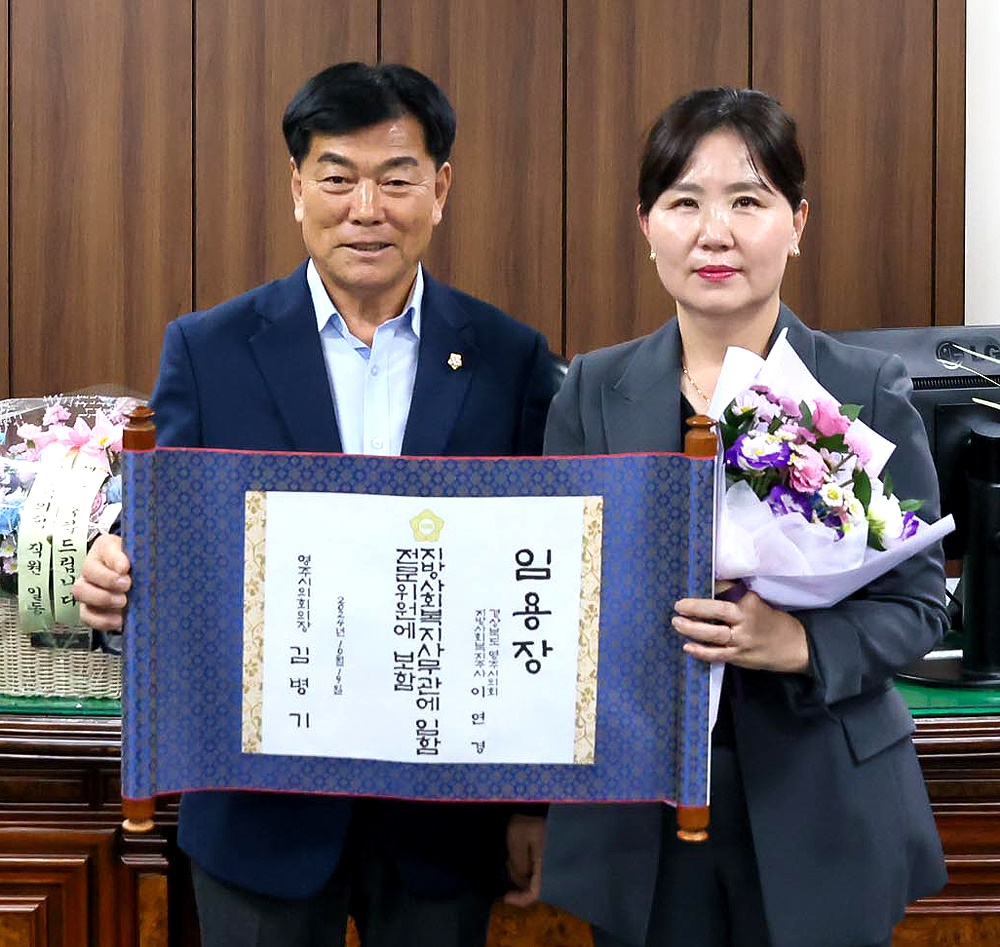 사무관에 승진한 이인경 전문위원이 김병기 의장으로부터 임용장을 받고 있다(영주시 의회 제공)